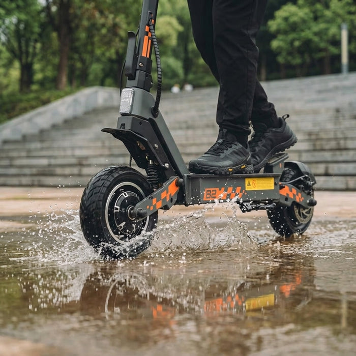 Kukirin G2 grise et orange traversant une flaque d eau - SteedyTrott.com