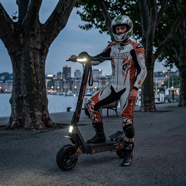 Pilote équipé posant avec la Kukirin G4 en ville de nuit - SteedyTrott.com